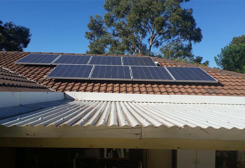 Dach eines Einfamilienhauses mit Photovoltaikanlage, gefördert durch KfW 308 – nachhaltige Energielösung bei sonnigem Wetter.
