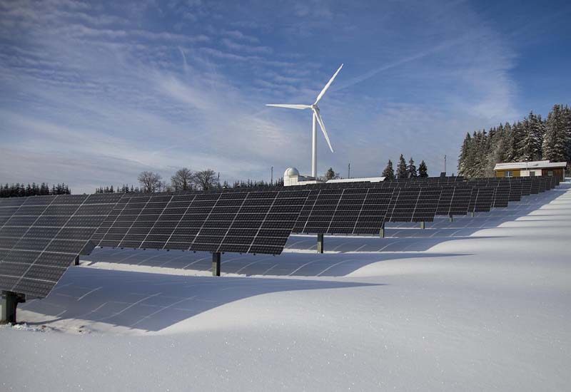Solarkraftwerk im Vordergrund und Windkraft im Hintergrund – erneuerbare Energien im Fokus der KfW Umweltförderung